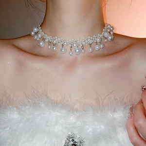 Detail of elegant multilayer pearl choker necklace with tassel pendants on model