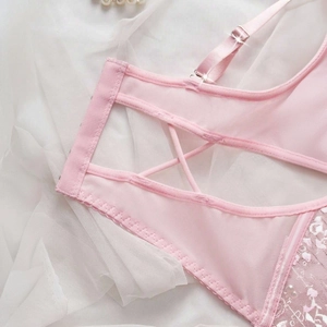 Pink lace lingerie set with intricate embroidery and cross-back straps detail