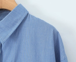 Detailansicht des blau-weiß gestreiften Hemdkragens mit Präzisionsnähten und feiner Textur