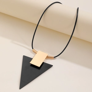 Détail du collier géométrique avec pendentif bicolore sur cordon de chaîne noir