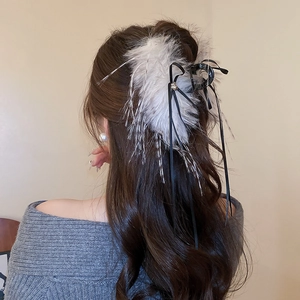 Detail view of large fur hair claw clip with black silk ribbon bow and pearl accents
