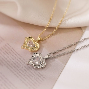 Close-up of gold and silver heart pendants with cubic zirconia in lava design