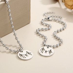 Detail of silver family pendant necklace and bracelet set with round bead chains