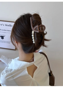Détail d'une pince à cheveux mate marron avec perles pour un chignon élégant et raffiné
