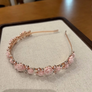 Detail of rose gold headband with pink resin roses, white pearls and sparkling rhinestones