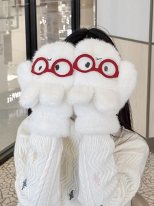 Detail of white plush convertible mittens featuring a cute monster face with red glasses