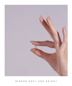 Detail of a small gold moon earring with sparkling clear cubic zirconia stones