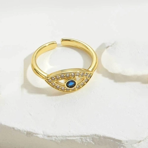 Detailed close-up of gold evil eye ring with blue zircon center and sparkling white stones