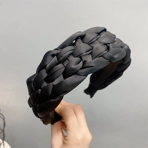 Detailed view of black braided satin headband with elegant twisted texture and rhinestones