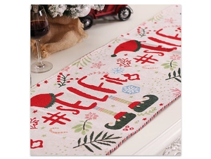 Close-up of festive Christmas table runner with knitted tassel and red #SELFIE print