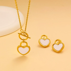 Détail de l'ensemble collier et boucles d'oreilles avec pendentif cœur doré et émail blanc