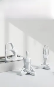 Detailed view of three white ceramic yoga girl figurines with elegant matte finish