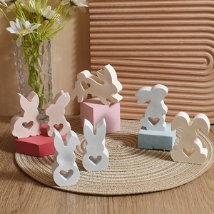 Detail shot of seven pastel Easter bunny figurines with hollow heart shapes on a jute mat