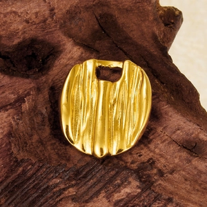 Irregular golden stainless steel round pendant with vertical striped texture on wood
