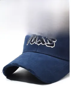 Detail of distressed navy blue baseball cap brim with white letter embroidery and stitching