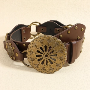Détail d'une ceinture bohème marron avec boucle fleurie en bronze et rivets
