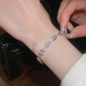 Close-up of golden geometric oval zircon bracelet with sparkling crystals on a wrist