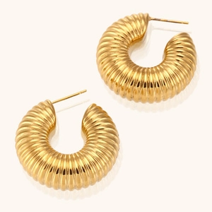 Macro detail of 18K gold plated stainless steel croissant dome stud earrings on white