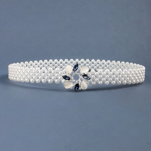 Detail of multi-row pearl waist chain featuring a blue floral gem buckle on metal base