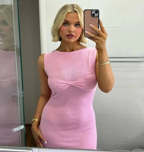 Gros plan sur la robe en tricot rose sans manches avec détail de nœud torsadé devant
