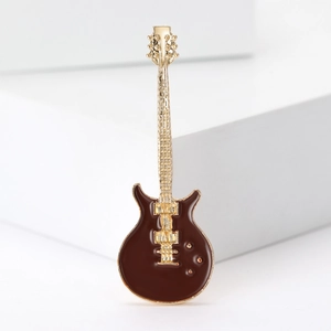 Detailed view of an electric guitar brooch with dark brown enamel and golden alloy accents