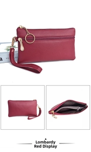 Detail of burgundy lychee leather clutch bag showing triple zipper compartments and wristlet