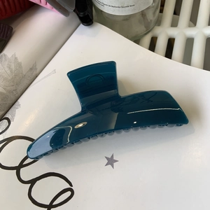 Macro detail of glossy dark blue shark hair claw clip with smooth polished finish