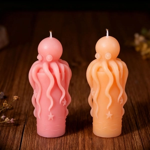 Artistic octopus pillar candles in pink and orange colors with starfish and wave textures