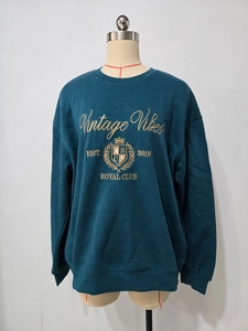 Detail von petrolfarbenem Sweatshirt mit goldener Vintage Vibes Stickerei auf Stoff