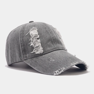 Détail de la casquette de baseball en jean gris foncé avec trous vieillis et franges