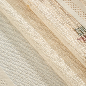 Macro shot of beige lace curtain fabric with geometric grid pattern and fine embroidery