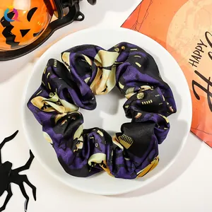 Close-up of Halloween satin scrunchie with pumpkin patterns on a festive tray
