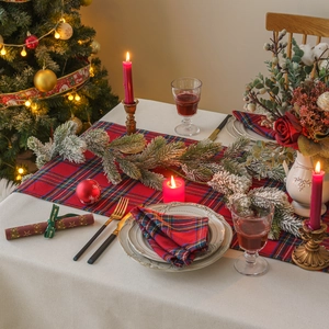 Red plaid Christmas table runner set with placemats and festive holiday decorations