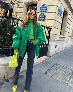 Street style view of oversized emerald green bomber jacket with grey straight-leg jeans