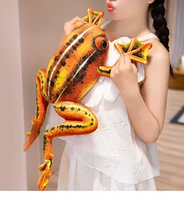 Close-up of large orange and black spotted plush frog toy held in a person's arms