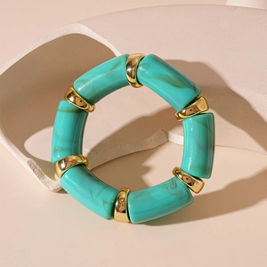 Detail of vintage teal marble acrylic bamboo bracelet with polished gold metal rings