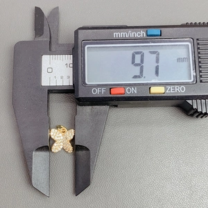 Macro shot showing crystal butterfly pendant width measurement of 9.7mm with digital caliper