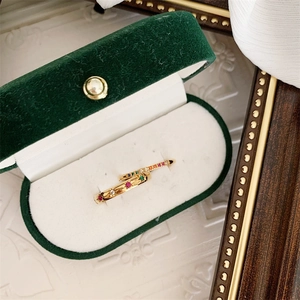 Detail van 18k vergulde ringen met regenboog zirkonia in een groene fluwelen doos