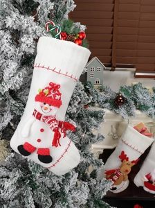 Detail of white knit Christmas stockings with 3D snowman and reindeer decorations