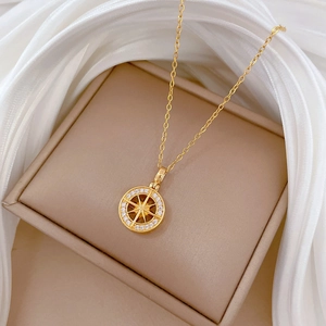 Elegant gold titanium steel necklace with starburst pendant on luxury silk fabric