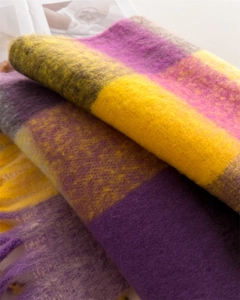 Close-up of thick plaid scarf featuring soft cashmere-like texture and fringed edges