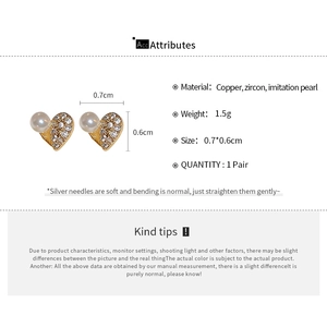 Detail view of heart stud earrings with zircon and pearl, size 0.7x0.6cm and gold finish