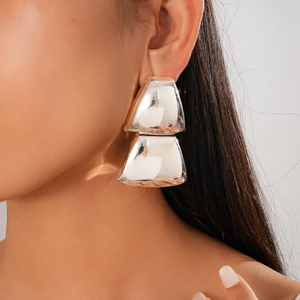 Close-up of geometric double triangle silver earrings on a model showing minimalist style