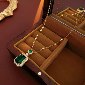 Close-up of emerald green rectangular necklace pendant in a luxury wooden jewelry box