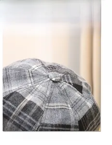 Detail of grey plaid octagonal beret cap showing high-quality wool texture and pattern