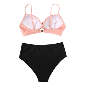 Detail view of pink bikini top with thin straps and black high-waisted bottoms on white background