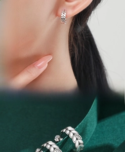Detail of silver leaf hoop earrings featuring wheat patterns and micro-set cubic zirconia