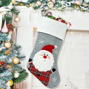 Detailed view of grey Christmas stocking with Santa embroidery in festive home setting