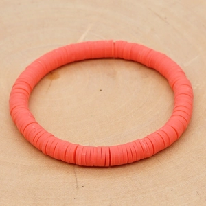 Detailopname van bohemian koraaloranje polymeerklei armband op houten achtergrond