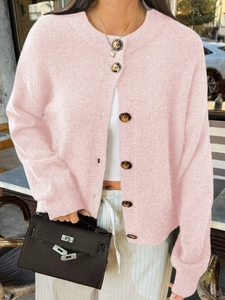 Détail du cardigan en tricot rose avec des boutons marron et une encolure ronde classique
